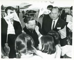 Carl Albert standing with several Korean children who are waving Korean and American flags. This was taken during the trip to Korea., 1950-01-01 - 1976-12-31