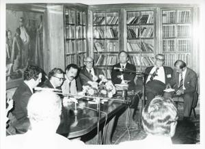Carl Albert seated at a conference table with other men. House delegation trip. August 1975, 1975-08-04