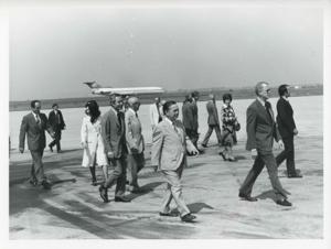 Carl Albert with several other people walking outside at an airport., 1975-08-04