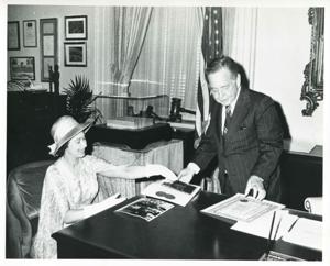 Carl Albert and Queen Elizabeth looking at photographs on Albert&#39;s desk. 1976, 1976-07-06
