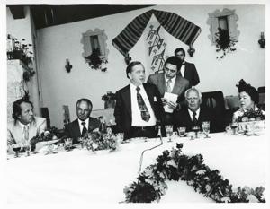 Carl Albert standing near a dinner table while others are sitting. House delegation trip. August 1975, 1975-08-04 - 1975-08-29