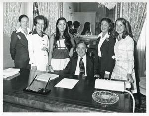 Carl Albert seated at his desk, with Karen Knight, Pam Morton (intern), and Donna Nix(and family) standing around him., 1950-01-01 - 1976-12-31