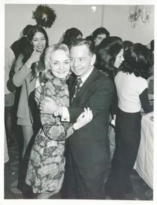 Polly Ritter hugging Carl Albert at the Staff Christmas Party. Sherry Tonubbee Stewart is standing in the background, 1971, 1971-12-01