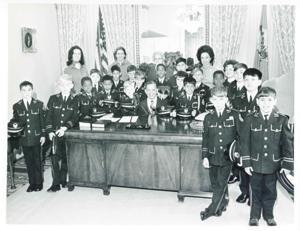 Carl Albert seated at his desk and posing with several young boys from Linton Hall., 1950-01-01 - 1976-12-31