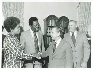 Carl Albert shaking hands with Mrs. Aaron as Hank Aaron looks on. July 14, 1974, 1971-07-14