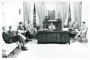 Carl Albert seated at his desk. Several men are seated around the desk., 1950-01-01 - 1976-12-31