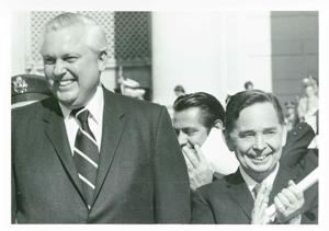 Carl Albert standing next to David Hall. Photo is taken outdoors. Both men are clapping., 1950-01-01 - 1976-12-31