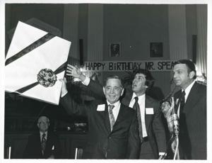 Carl Albert holding up one of his birthday presents. Tom Steed and Ray Harris are also shown., 1976-05-10
