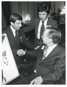 Carl Albert seated in a chair shaking hands with an unidentified man., 1976-05-10