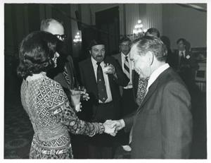 Carl Albert shaking hands with an unidentified woman at his birthday party, 1976, 1976-05-10