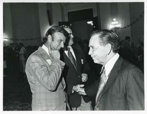 Carl Albert shaking hands with an unidentified man at his birthday party, 1976, 1976-05-10