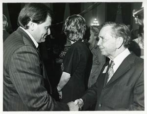 Carl Albert shaking hands with an unidentified man at his birthday party, 1976, 1976-05-10