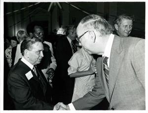 Carl Albert shaking hands with an unidentified man at his birthday party, 1976, 1976-05-10