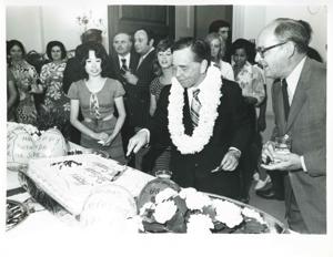 Carl Albert cutting the cake for his birthday party as Sue Thomson and others look on. May 10, 1974, 1974-05-10