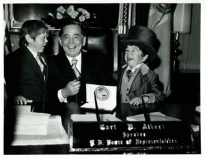 Carl Albert seated at his desk with two midgets from the Ringling Bros. and Barnum and Bailey Circus., 1950-01-01 - 1976-12-31