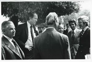 Carl Albert standing and talking with several other men. House delegation trip. August 1975, 1975-08-04