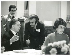Carl Albert speaking with an unidentified man at a reception for freshman members of the 94th Congress. Joel Jankowsky is in the background. December 1, 1975, 1975-12-01