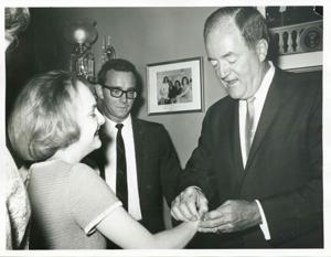 Hubert H. Humphrey putting a bracelet on Polly Ritter., 1950-01-01 - 1976-12-31