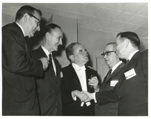 Carl Albert shaking hands with an unidentified man. Mike Mansfield and others are also present., 1950-01-01 - 1976-12-31