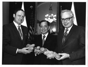 Carl Albert, James R. McClure, and Congressman George V. Hansen from Idaho holding potatoes., 1971-05-01