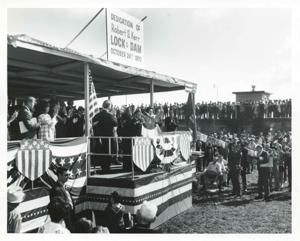 George Nigh speaking at the dedication of the W. D. Mayo and Robert S. Kerr locks and dams. Also present are Robert S. Kerr, Jr., Dewey F. Bartlett, Lady Bird Johnson, Ed Edmondson, Carl Albert, Fred Harris, and Lyndon B. Johnson. October 24, 1970, 1970-10-24