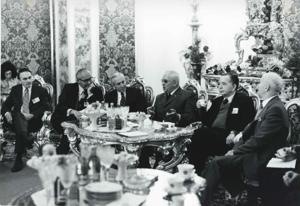 Carl Albert seated with several men. House delegation trip. August 1975, 1975-08-04