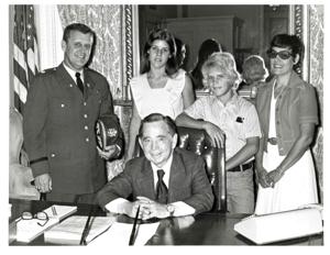 Carl Albert with Mrs. Lottie Ross holding a picture of an old schoolhouse with students in front. November 20, 1975, 1975-11-20