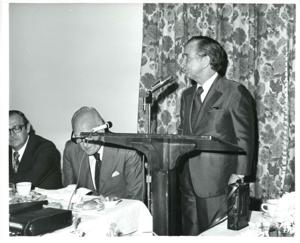Carl Albert standing behind a speaker at a podium., 1970-01-01 - 1976-12-31